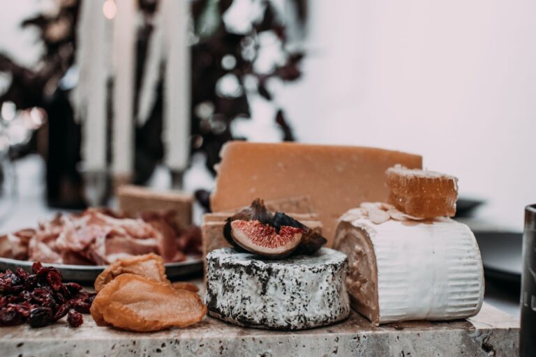 Formaggi stagionati, salumi affettati e fichi secchi esposti sul banco di una bottega alimentare