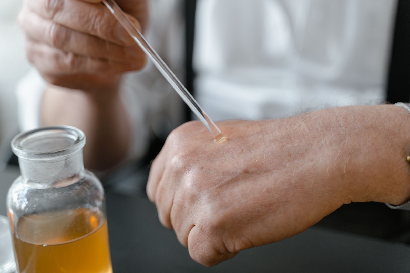 Prova di una fragranza: una goccia di essenza viene posata con una pipetta di vetro sul dorso della mano